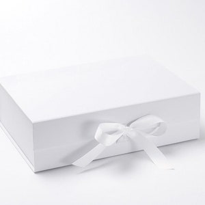 May include: A white gift box with a white satin ribbon tied in a bow.