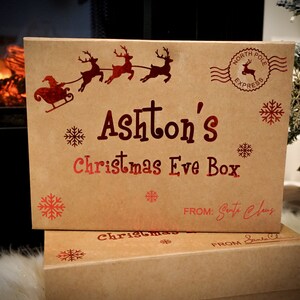 Custom Santa box in Christmas setting in front of warm fireplace. Box is decorated in a red chrome design with santa sleigh, snowflakes and stamp from the north pole.