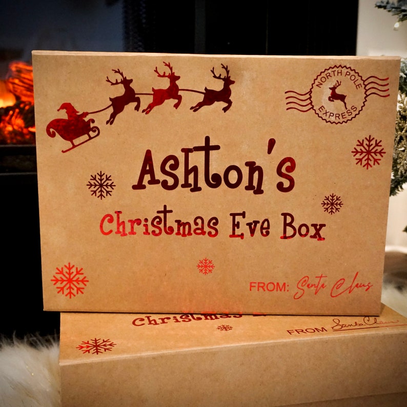 Custom Santa box in Christmas setting in front of warm fireplace. Box is decorated in a red chrome design with santa sleigh, snowflakes and stamp from the north pole.