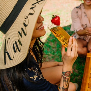 A custom beach hat adorned with a personalized ribbon, embodying honeymoon chic. This sun hat, ideal as a honeymoon gift, features an oversized brim for ultimate sun coverage.