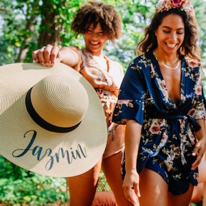 A monogrammed floppy sun hat, radiating timeless elegance, perfect for the future Mrs. The wide brim offers sun protection, making it an ideal gift for bachelorette parties and bridal showers.