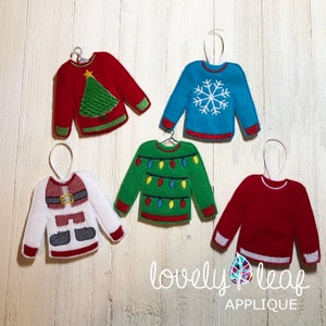 Può includere: Cinque decorazioni natalizie in feltro a forma di maglioni con diversi disegni. I maglioni sono rossi, blu, verdi, bianchi e rossi. I disegni includono un albero di Natale, un fiocco di neve, luci natalizie, Babbo Natale e un maglione semplice.