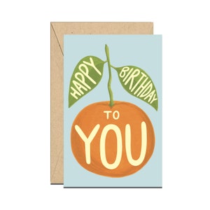 May include: A light blue card with a cartoon orange with green leaves. The orange has the words "Happy Birthday to You" written on it.