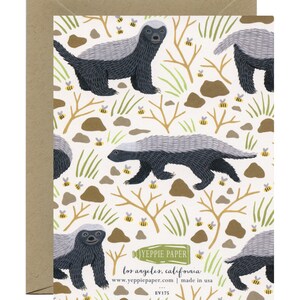 May include: A white card with a repeating pattern of honey badgers and bees. The honey badgers are black and gray with white stripes. The bees are yellow and black. The card has the text "YEPPIE PAPER" in green and the text "los angeles, california" in black. The card also has the text "www.yeppiepaper.com | made in usa" in black. The card has the text "EVI75" in black.