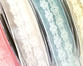 May include: Four spools of sheer ribbon with a delicate floral lace pattern. The ribbon colors are pink, white, light blue, and beige.
