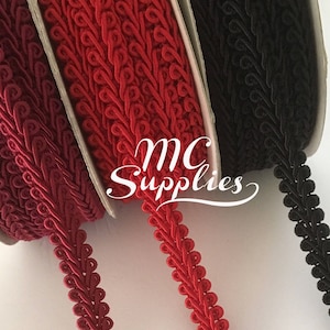 May include: Three spools of trim, one red, one burgundy, and one black. The trim is a decorative cord with a repeating pattern of small loops.