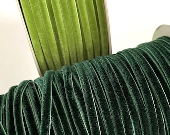 May include: Two spools of velvet ribbon, one green and one dark green. The ribbon is wound around the spools and is ready to be used for crafting or decorating.