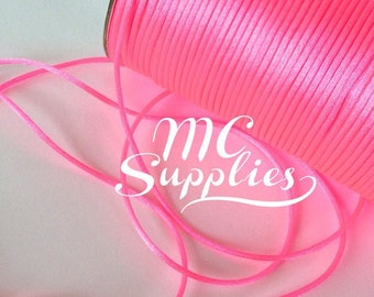 May include: A spool of bright pink satin cord. The cord is wound tightly around the spool and is ready to be used for crafting projects.