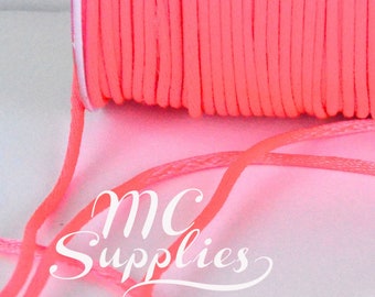 May include: A spool of bright coral-colored cord with loose strands in the foreground. The cord is tightly wound on a white spool. The text "MC Supplies" is visible in the image.