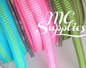 May include: Four spools of ribbon with different colored stripes. The ribbons are turquoise with green stripes, pink with white stripes, green with brown stripes, and brown with green stripes.