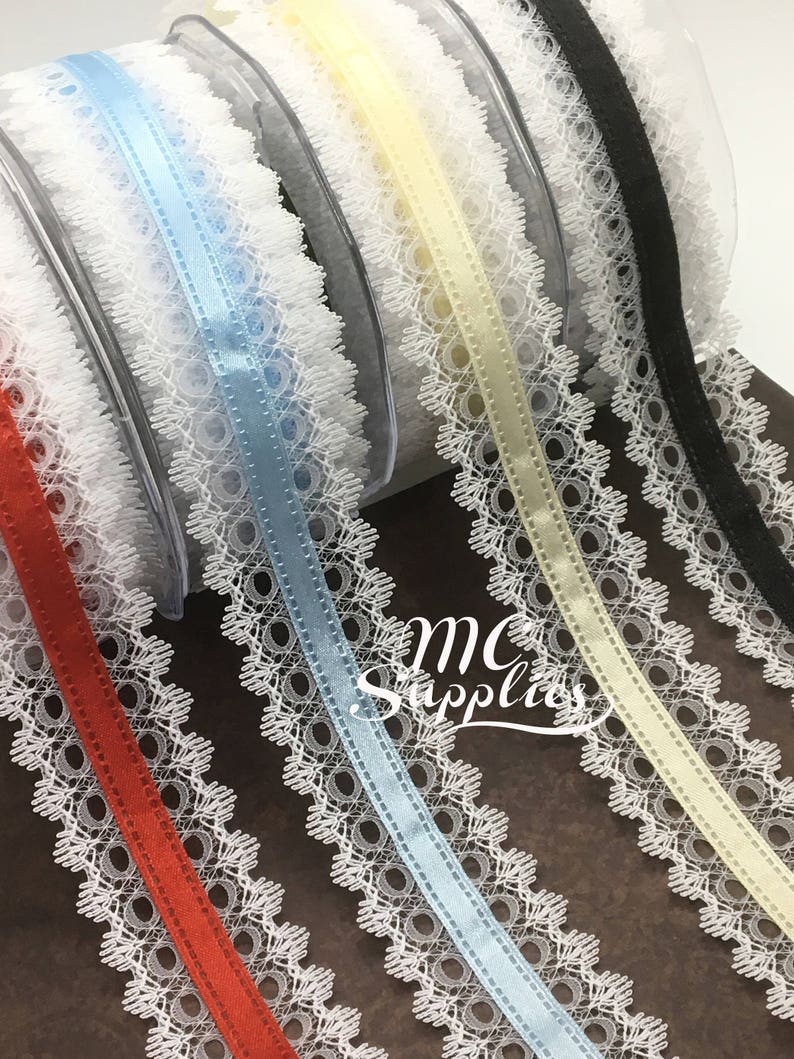 May include: Assortment of white lace trim with different colored satin ribbon centers. The colors include red, light blue, yellow, and black.