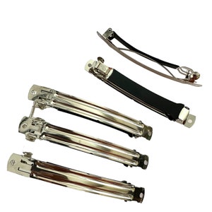 May include: Five silver hair clips, four are plain and one has a black rubber grip.