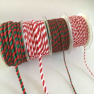 May include: Three spools of red and white, red and green, and green and white baker's twine.