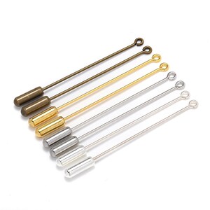 May include: A set of six straight pins with different colored metal finishes. The pins have a loop at one end and a cylindrical head at the other. The colors are gold, silver, and bronze.