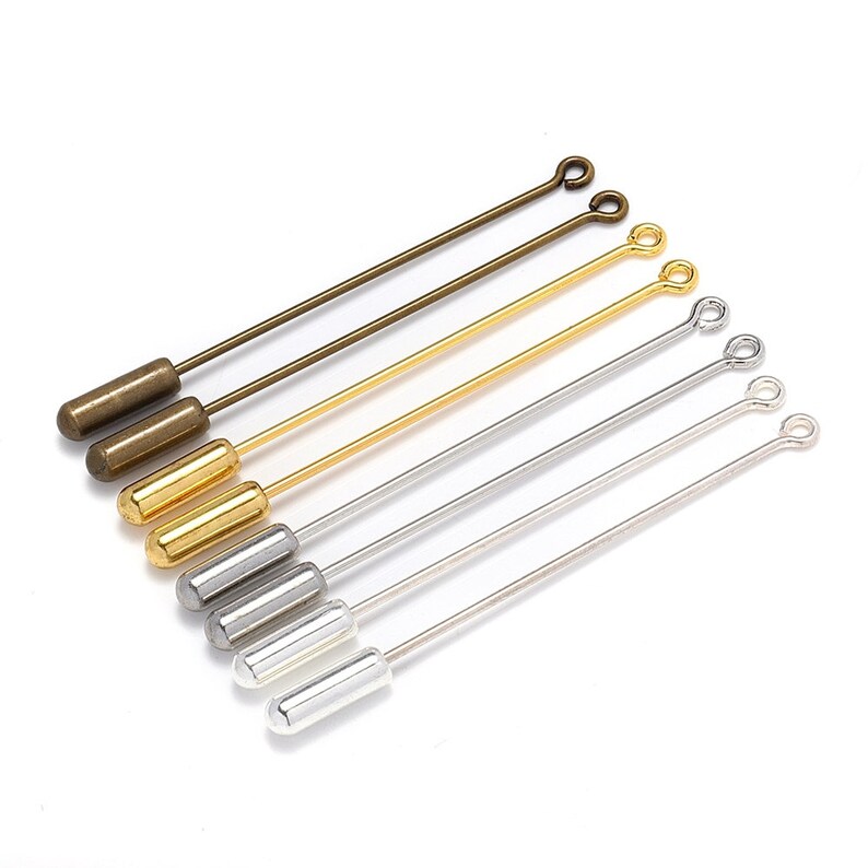 May include: A set of six straight pins with different colored metal finishes. The pins have a loop at one end and a cylindrical head at the other. The colors are gold, silver, and bronze.