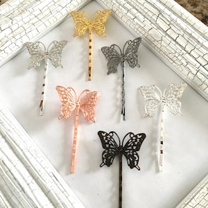 May include: Six butterfly hair clips in different colors: gold, silver, rose gold, copper, and black. The butterfly designs are intricate and delicate.