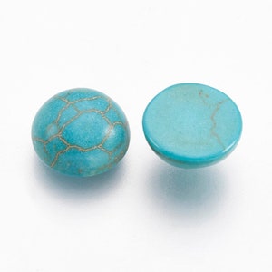 May include: Two turquoise cabochons, one with a marbled pattern and the other with a smooth surface.