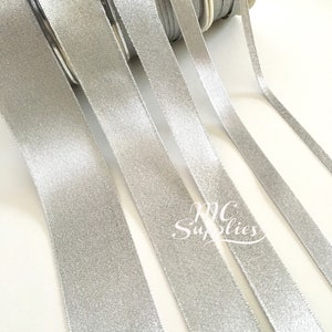May include: Silver glitter ribbon spools. The ribbon is a satin finish and has a subtle shimmer.