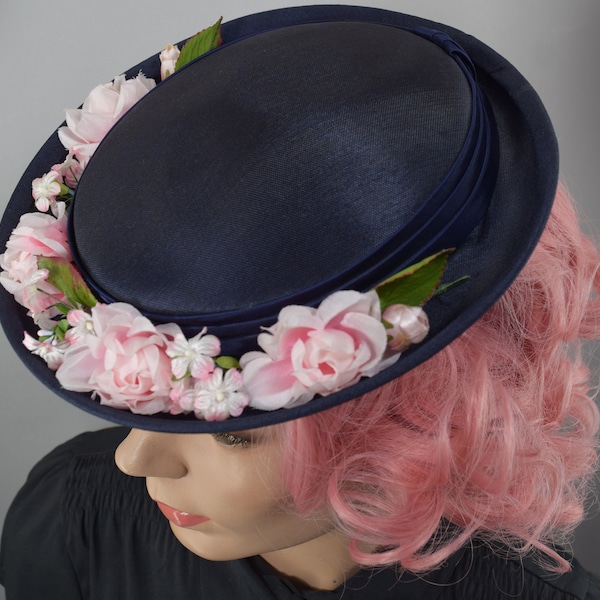 Sombrero ladeado vintage azul marino de los años 50 con racimos de flores rosas.