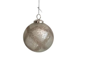 May include: A silver Christmas ornament with a frosted finish and a brown leaf design.