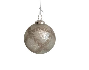 May include: A silver Christmas ornament with a frosted finish and a brown leaf design.
