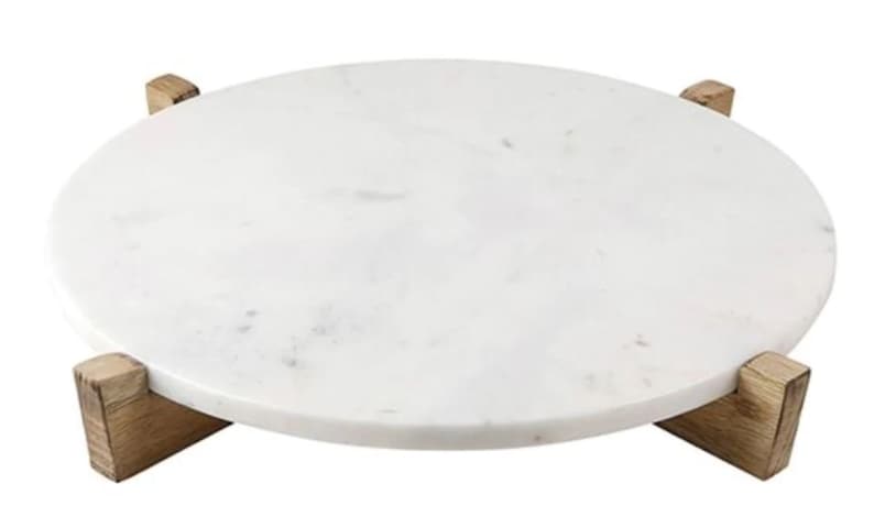 Pu&ograve; includere: Vassoio rotondo da portata in marmo bianco con quattro gambe in legno.