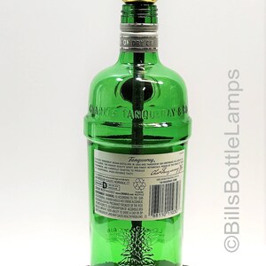 May include: A green glass bottle lamp with a wooden base. The bottle is labeled "Charles Tanqueray & Co. London Dry Gin".