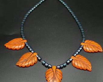 Gray Hematite Beads Contrast with Orange Howlite Leaves in Princess Length Necklace.