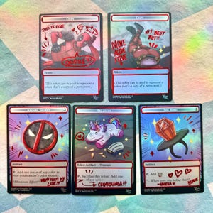 May include: Five collectible trading cards with red borders and unique illustrations. The cards feature Deadpool-themed art, including a cartoon Deadpool character, a unicorn, and a large ring. Text includes "COPY", "Token", and various phrases.