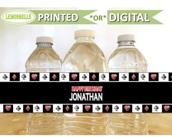 May include: Three clear plastic water bottles with black and white playing card themed labels. The labels have red hearts, spades, clubs, and diamonds. The text on the label reads "Happy Birthday Jonathan".