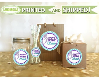 May include: Set of four round stickers with a mermaid design. The stickers feature a turquoise background with a purple and silver glitter mermaid. The text on the stickers reads "Happy Birthday Sarah".