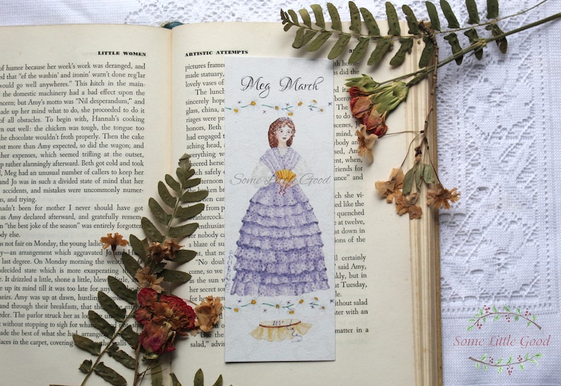 May include: A purple and white bookmark with a hand-painted illustration of a woman in a purple dress. The bookmark features the text "Meg March" and "Some Little Good".