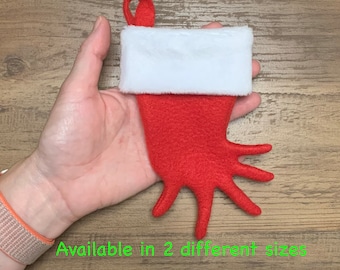 May include: Red felt Christmas stocking shaped like a hand with a white faux fur cuff.  Available in 2 different sizes.