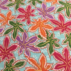 May include: A teal blue fabric with a repeating pattern of colourful leaves. The leaves are in shades of pink, orange, purple, green, and yellow. The leaves have a white outline and are set against a background of small white dots.