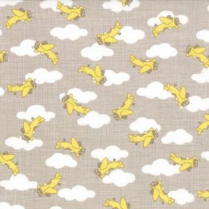 Puede incluir: Una tela beige con un patrón repetitivo de aviones amarillos volando en nubes blancas.