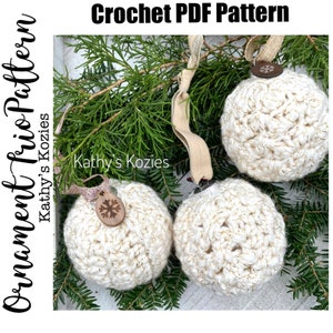 May include: Three crocheted white Christmas ornaments with gold glitter accents. The ornaments are hanging from a branch with a brown snowflake embellishment on each.