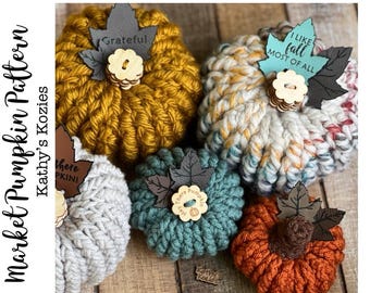 Può includere: Cinque zucche all'uncinetto in vari colori e dimensioni. Le zucche sono decorate con foglie di stoffa e bottoni a tema autunnale. Il testo sulle foglie recita "Grateful", "There Pumpkin", "I Like Fall Most Of All" e "There Pumpkin".