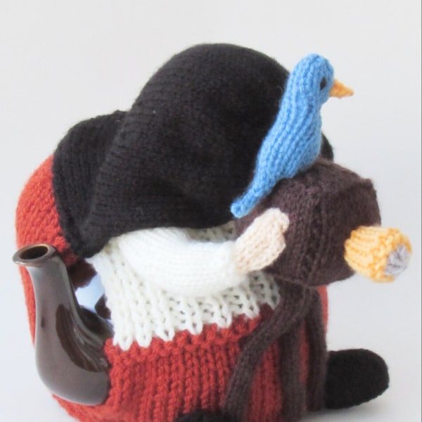 Photographer Tea Cosy Knitting Pattern to knit your own vintage cameraman tea cosy, with his camera on a tripod