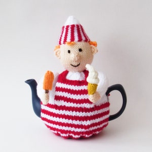 Könnte beinhalten: Eine rot-weiß gestreifte gestrickte Teekannenhülle in Form einer Person, die einen rot-weiß gestreiften Hut trägt und ein orangefarbenes Eis am Stiel und eine weiße Eistüte hält.