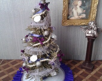 Miniature Christmas tree with basket of dollhouse ornaments in purple, white and silver