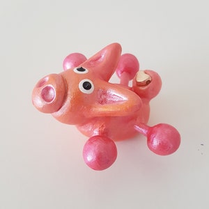 Peachy Pink Hugger Piggie - whimsical cute pet pig with a rose gold heart, delightful sweet clay figurine, desk buddy animal ornament.