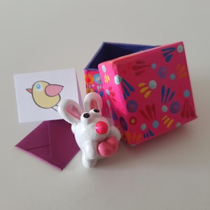 Weißes Häschen mit rosa Herz in einer rosafarbenen Geschenk-Box - wunderliche Love Ornament, Ton Tier, Haustier Kaninchen, Schreibtisch Buddy, Birdie mini Karte.