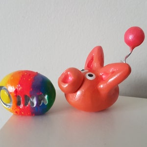 Piggy Oink - whimsical cute peachy pink pet pig and a rainbow clay pebble rock Oink, delightful sweet clay desk buddy animal ornament.