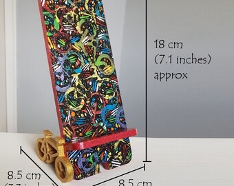 Wooden phone stand holder with a bicycle in gold colour, black red with rainbow multi-coloured patterns, artistic stylish funky phone stand.
