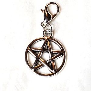May include: Silver-toned charm featuring a pentagram design. The charm is attached to a lobster clasp for easy attachment to a bracelet or necklace. The pentagram is a five-pointed star within a circle.