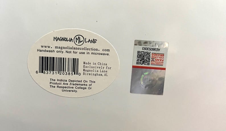 Pu&ograve; includere: Immagine con due adesivi. Uno &egrave; un adesivo ovale con il testo "MAGNOLIA LANE" e informazioni sul prodotto. L'altro &egrave; un adesivo rettangolare con un codice QR e il testo "COLLEGE FANS BRANDS".