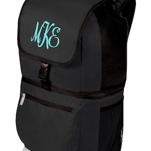 May include: A black insulated backpack with a zippered pocket and a mesh side pocket. The backpack has a monogrammed "MKE" on the front flap.