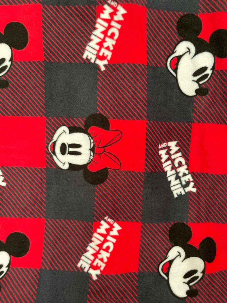 May include: Red and black plaid fabric with a repeating pattern of Mickey Mouse and Minnie Mouse. The text "Mickey and Minnie" is printed in white on the fabric.