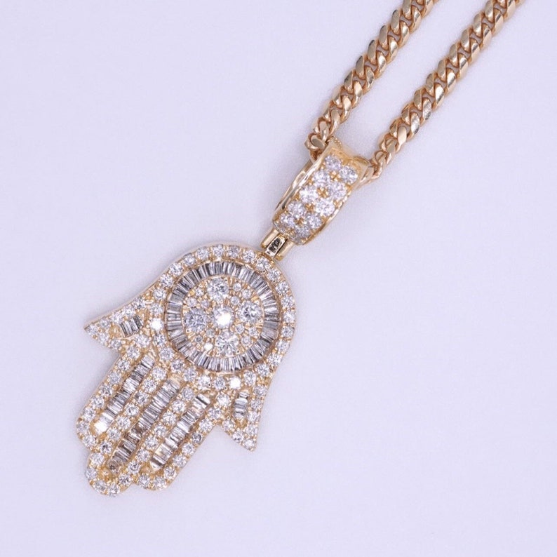 Close-up of real gold Hamsa charm with smooth finish and symbolic hand design. Mini Hamsa hand gold pendant shown on gold necklace chain for layering.