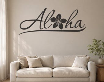 May include: A dark brown wall decal featuring the word Aloha in a cursive script font, with a five-petaled flower replacing the letter o. The design includes a long, sweeping underline that extends from the start of the word to the end.
